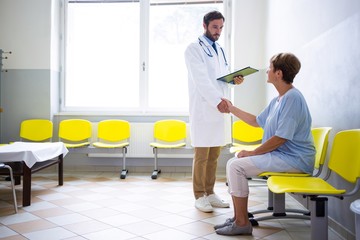 Wall Mural - Doctor shaking hand with patient in waiting room