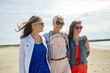 © Syda Productions - group of smiling women in sunglasses on beach
