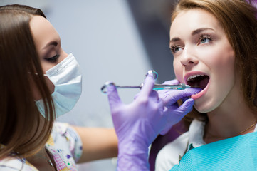 Dentist curing a child patient in the dental office in a pleasant environment. There are specialized equipment to treat all types of dental diseases in the office.