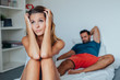 © jakubzak - Young couple is sitting on the bed while woman is thoughtful and