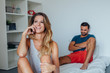 © jakubzak - Young couple is sitting on the bed while woman is talking by the