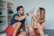 © jakubzak - Young couple are giving each other a high-five. Bedroom backgrou
