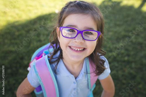 Fotografie, Obraz A girl wearing a uniform and a backpack is ready for her first day of school