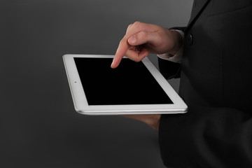 Poster - Businessman with tablet on grey background