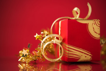 Wall Mural - red gift box with golden ribbons on red background. merry christmas.