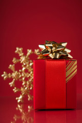 Wall Mural - red gift box and xmas snowflake on red background. merry christmas.