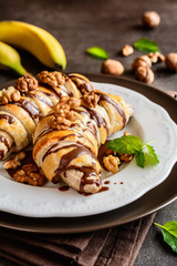 Wall Mural - Baked banana coated in puff pastry, topped with chocolate and walnuts