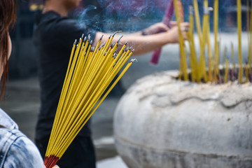 People holding joss sticks praying at the temple