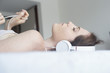 © PhotoAlto - Woman wearing headphones lying down