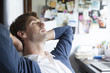 © PhotoAlto - Young businessman relaxing in home office