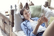© PhotoAlto - Young woman relaxing with smartphone and headphones
