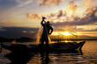 Silhouettes of the traditional stilt fishermen at sunset.