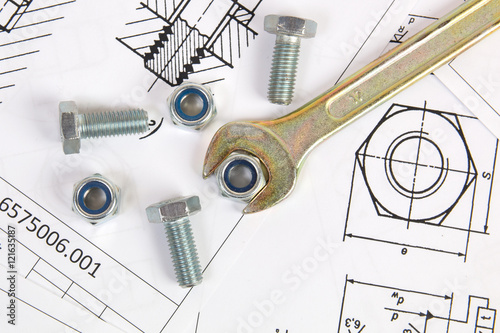 Fotografía Wrench, bolts and nuts on background of engineering drawings