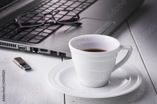 Nowoczesny obraz na płótnie Filiżanka kawy i laptop w tle