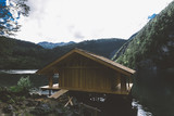 Fototapeta Do pokoju - Wood house on lake with mountains and trees