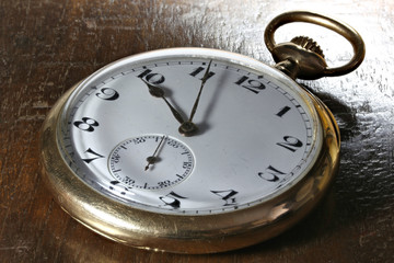 antique Swiss 14k gold pocket watch on wooden background