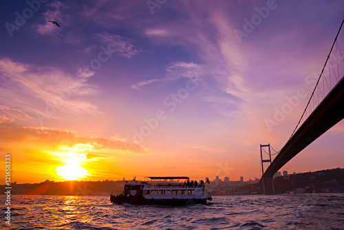 Bosphorus Bridge and excursion boat at sunset, Istanbul, Turkey. Poster