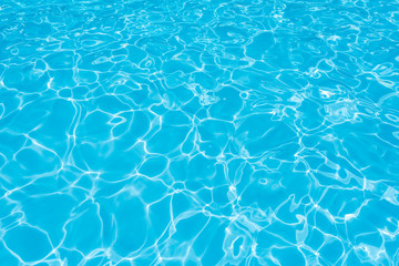 ripple water in swimming pool with sun reflection