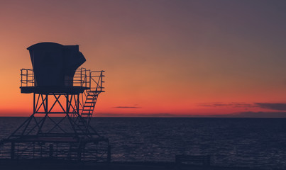 Vintage California sunset with life guard station silhouette