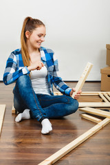 Wall Mural - Woman assembling wooden furniture. DIY.