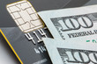 EMV chip on a credit card and $100 dollar bills.