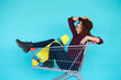 © kegfire - hipster woman with yellow skateboard sitting in shopping trolley