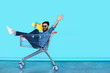 © kegfire - Side view of cheerful young man sitting in shopping cart
