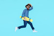 © kegfire - Pretty young bearded man jumping with yellow skateboard