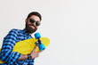 © kegfire - bearded hipster in checkered shirt holding yellow skateboard