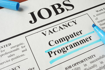 Newspaper with ads for vacancy Computer Programmer. Employment concept.