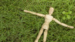 wooden human figure lay down on grass garden relax