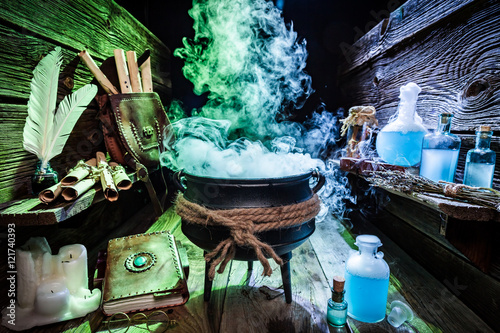 Fotografía Mysterious witcher cauldron with blue potions and books