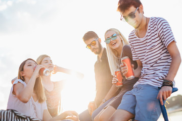 Group of friends drinking and having fun by the river