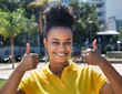 Beautiful woman with amazing hairstyle showing both thumbs up