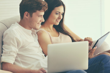 Beautiful couple surfing internet on tablet at home