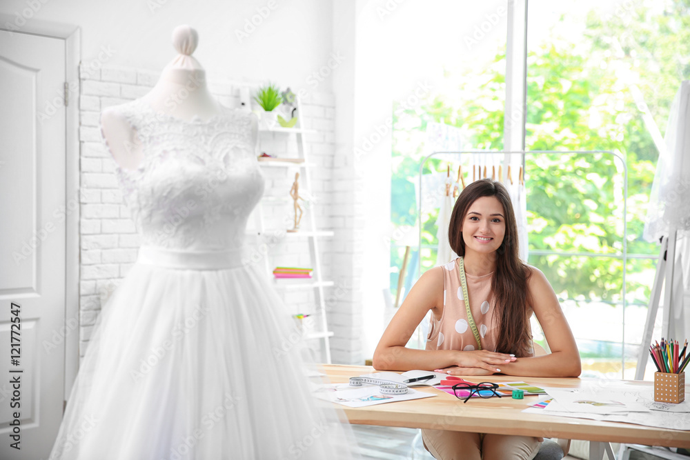 Pretty young dress designer at workplace