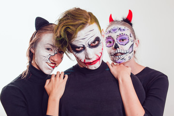 Wall Mural - Two girls and a guy with Halloween face art on white background