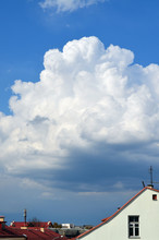 Roof Of The House Under A Large White Cloud. Big Cloud Over The City Rooftops