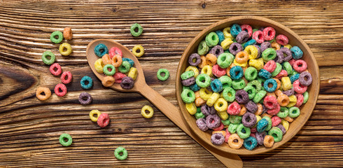 wooden spoon and wooden bowl with colorful cereal