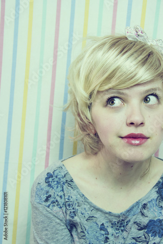 Chica Joven Rubia Con El Pelo Corto Mirando Hacia Un Lado Con Media Sonrisa Sobre Un Fondo De Rayas De Colores Buy This Stock Photo And Explore Similar Images At Adobe