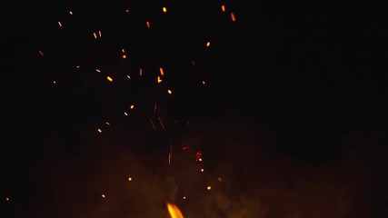 fire sparks from campfire over black background