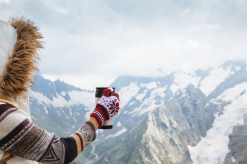 Wall Mural - Child drinking tea in thermos in mountains