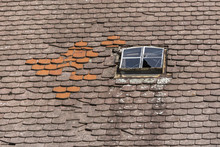 Old Broken Tile Roof With Damaged Window In Germany.
