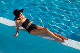 Fototapeta Niebo - Piękna kobieta w eleganckim kostiumie kąpielowym - relaks w basenie