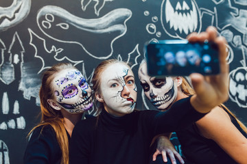 Wall Mural - Three girls going on Halloween, grimace make selfie  a dark background with  pattern