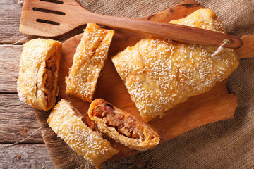 Canvas Print - Delicious puff pie stuffed with cabbage and sausages closeup. horizontal top view
