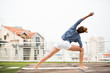 © rilueda - Beautiful woman doing yoga outdoors on a rooftop terrace