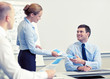 © Syda Productions - smiling woman giving papers to man in office