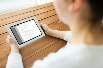 Poster - close up of woman with tablet pc on wooden table