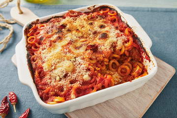 Baked anelletti pasta with mince, sauce and mozzarella. Typical sicilian dish